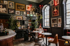 The bride and groom enjoy cocktails together at a quiet table inside Farrier & Draper bar in Dublin, Ireland